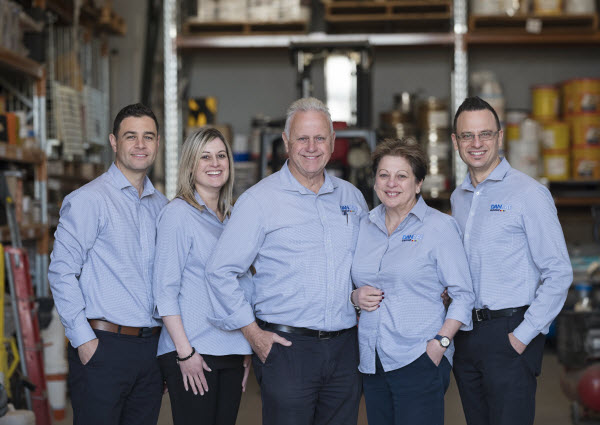 A team smiling at the camera inside a warehouse