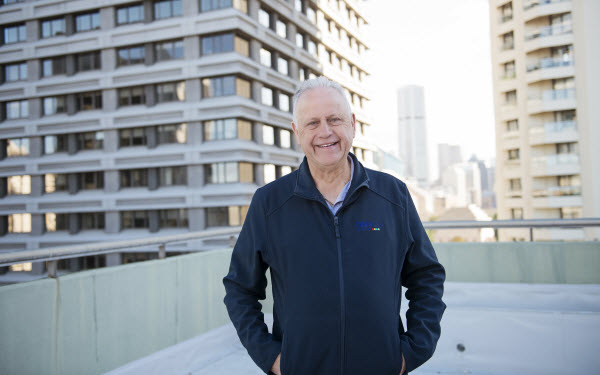 Happy man standing on the rooftop with buildings behind him