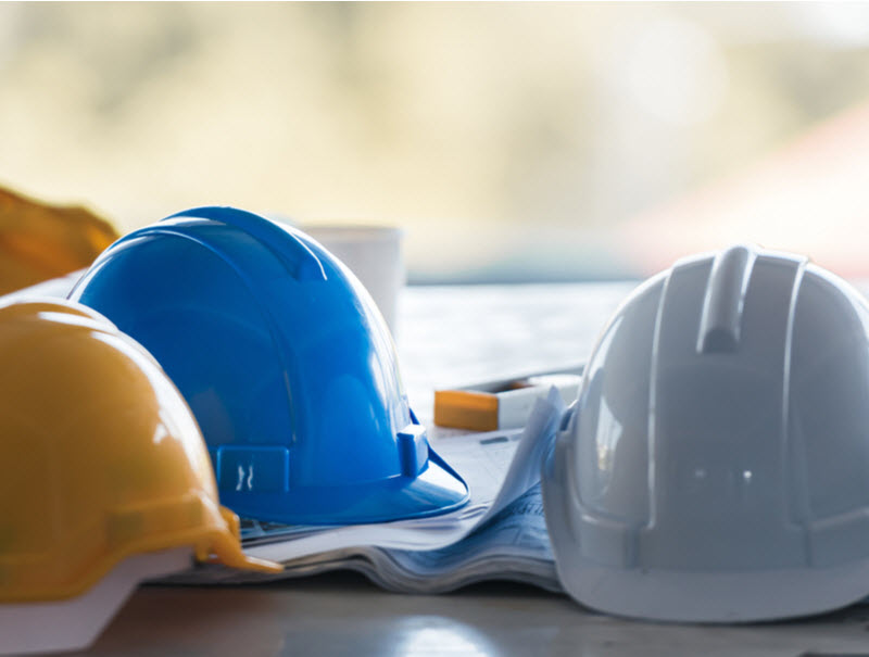 construction safety helmet put on the table with blue print.