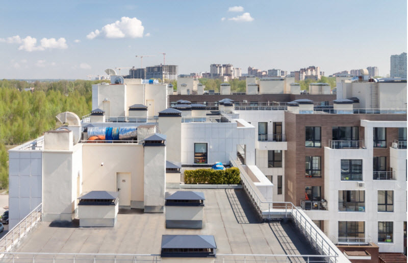 Flat roof with air conditioners on top modern apartment house building